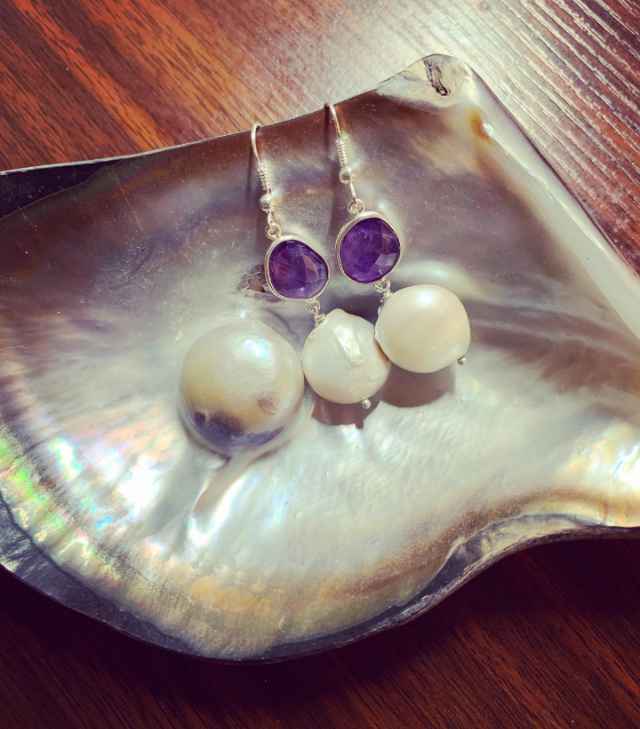 Mother of Pearl earrings on a shell